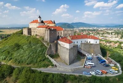 Castle of palanok and the foothills of carpathians mountains in mukachevo adobestock 209235681