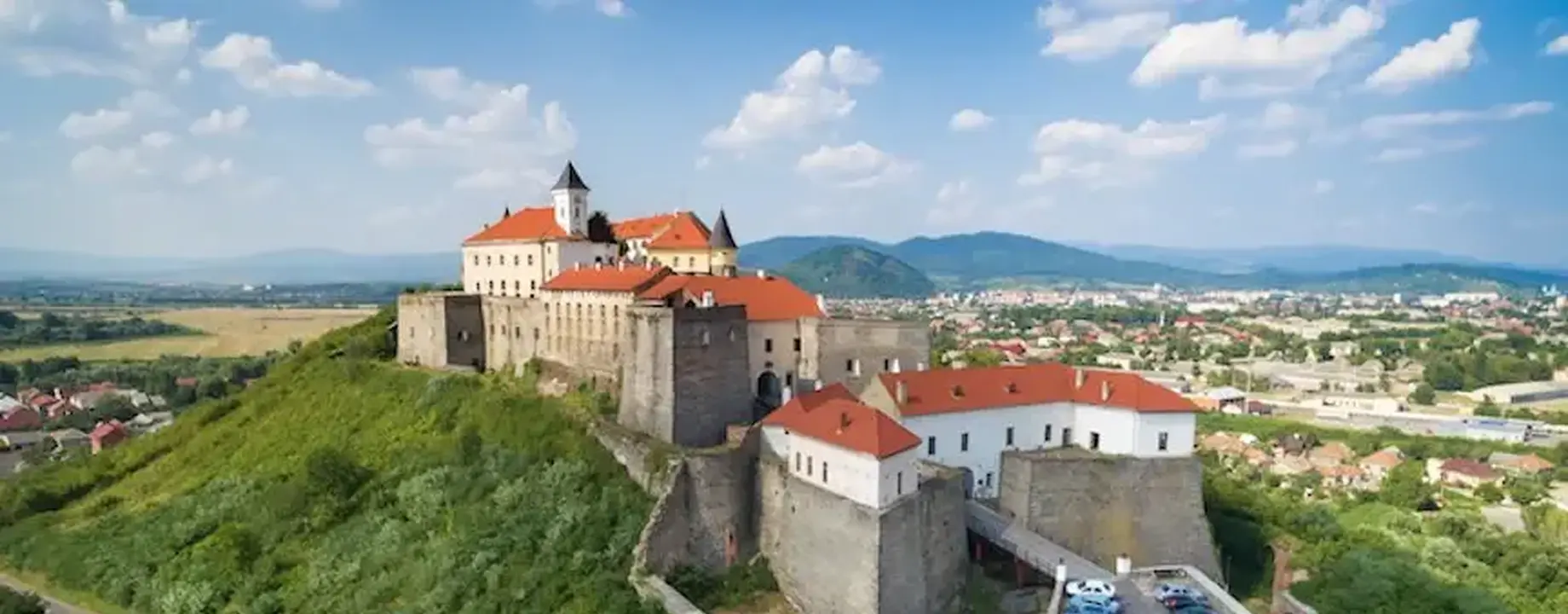 Castle of palanok and the foothills of carpathians mountains in mukachevo adobestock 209235681