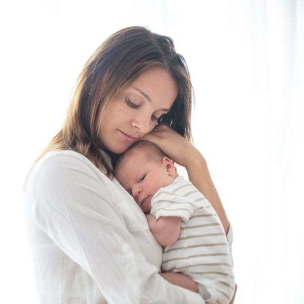 Young mother holding her newborn baby boy 845992464 2125x1416 scaled 1
